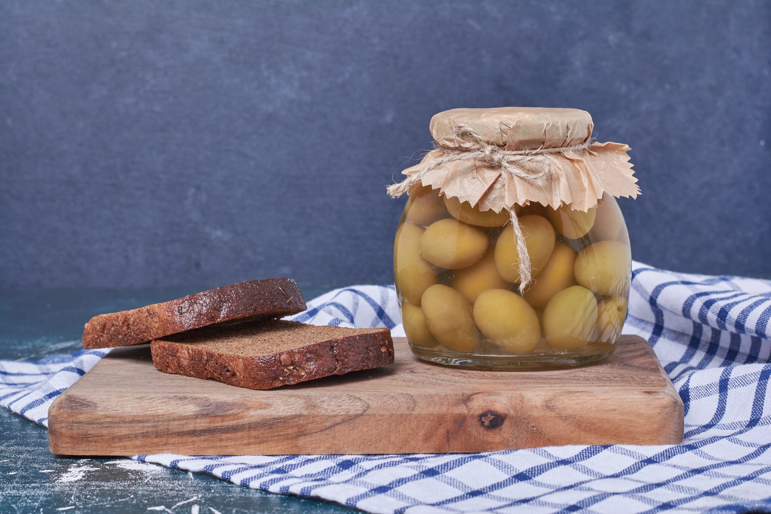 pickled olives glass jar with black bread slices blue scaled
